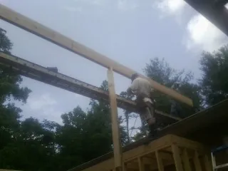 Carpenter setting a ridge beam over a new addition frame — Ice Dam Removal by Roofing Brothers in Dietrich