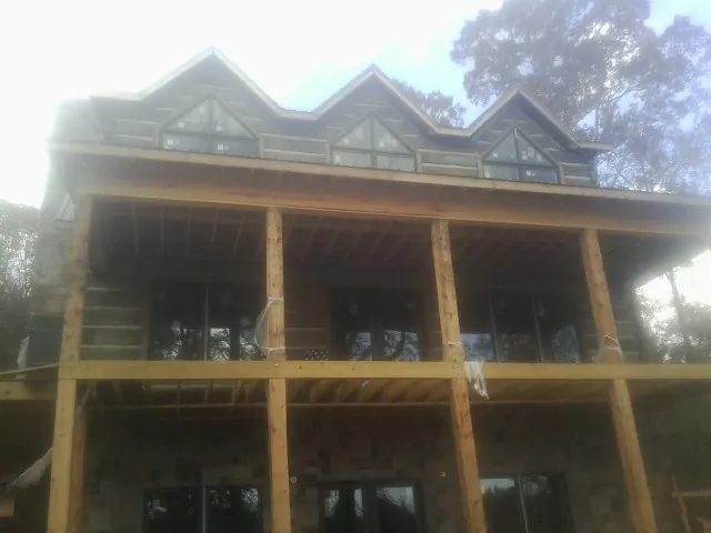 Dormers and porch framing on a large log home under construction — Roof Coating work by our crew in Dietrich