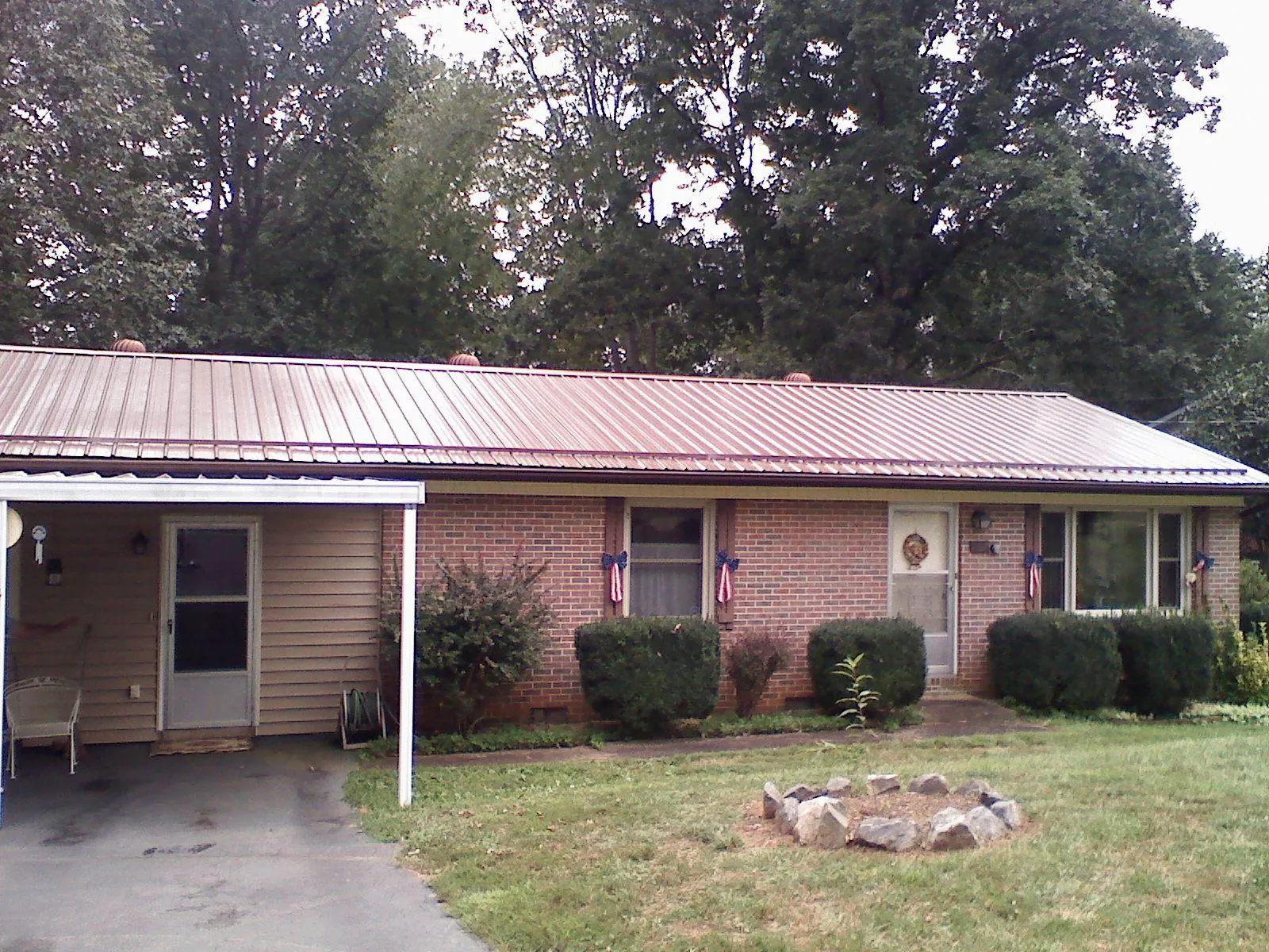 Bronze metal roof and carport on a brick ranch home — Roof Repair work by our crew in Dietrich